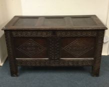 A Georgian oak hinged top coffer with carved front