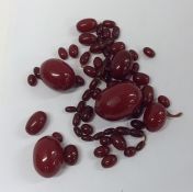 A bag containing tapering red amber beads of oval