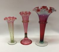 A group of three cranberry glass vases. Est. £25 -