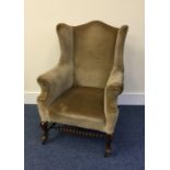 A tall Edwardian armchair with turned stretcher ba