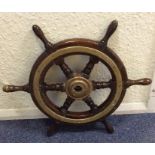 An Antique oak and brass mounted ship's wheel. Est