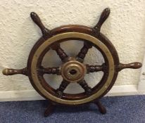 An Antique oak and brass mounted ship's wheel. Est