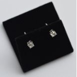 A pair of oval cushion set ear studs in claw mount