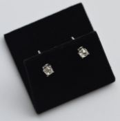 A pair of oval cushion set ear studs in claw mount