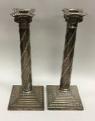 A pair of Edwardian silver candlesticks with swirl