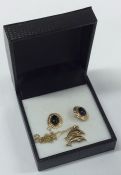 A pair of gold earrings together with a gold penda