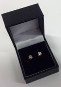 A pair of diamond single ear studs in two colour c