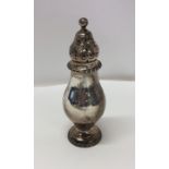 A stylish silver sugar caster with gadroon rim. Lo