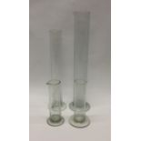 A group of four glass measures. Est. £20 - £30.