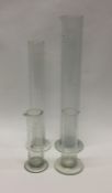 A group of four glass measures. Est. £20 - £30.