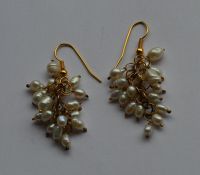 A pair of gold mounted and pearl drop earrings wit