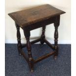 A Georgian oak coffin joint stool on stretcher bas