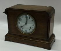 An oak cased mantle clock with white enamelled dia