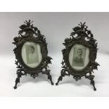 A pair of wrought iron oval picture frames attract