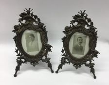 A pair of wrought iron oval picture frames attract