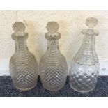 A group of three cut glass decanters with twisted
