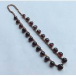 An unusual cabochon garnet and gold graduated neck