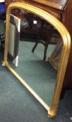 An oval top gilt mantle mirror on porcelain suppor