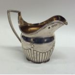 A silver half fluted cream jug with gilt interior.
