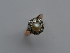 A diamond and pearl circular cluster ring in 18 ca