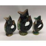 A set of three pottery gugglejugs in the form of f
