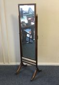 A mahogany dressing mirror on reeded supports. Est