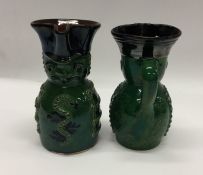 A pair of unusual pottery toby jugs decorated in g