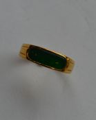 An 18 carat gold green stone ring with rubover mou