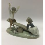 A Lladro figure of children upon a see-saw. Est. £