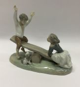 A Lladro figure of children upon a see-saw. Est. £