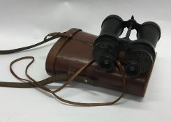 A pair of leather cased Military binoculars. By Ba