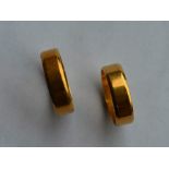 A pair of 18 carat gold wedding bands of plain des