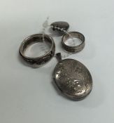 A small silver engine turned locket together with