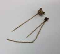 A large gold stick pin set with a fox's head toget