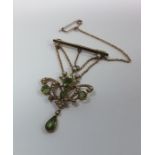 A 15 carat gold peridot and pearl drop pendant wit