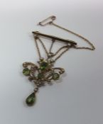 A 15 carat gold peridot and pearl drop pendant wit