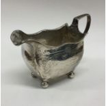 A Georgian silver bright cut cream jug with shaped