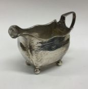 A Georgian silver bright cut cream jug with shaped