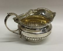 A Georgian silver cream jug of half fluted design