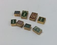 A group of various gold charms mounted with money.