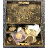 A metal money tin containing nickel and other coin