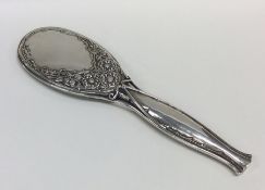 A stylish silver hand mirror decorated with flower