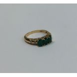 A good emerald three stone ring in claw mount with