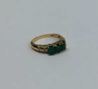 A good emerald three stone ring in claw mount with