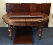 A massive mahogany oval dining table with six leav