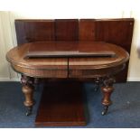 A massive mahogany oval dining table with six leav