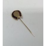 A heavy garnet mounted gold stick pin in the form