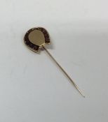 A heavy garnet mounted gold stick pin in the form