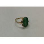 A gold and jade single stone ring in claw mount. A