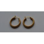 A pair of 9 carat hoop earrings of twisted design.